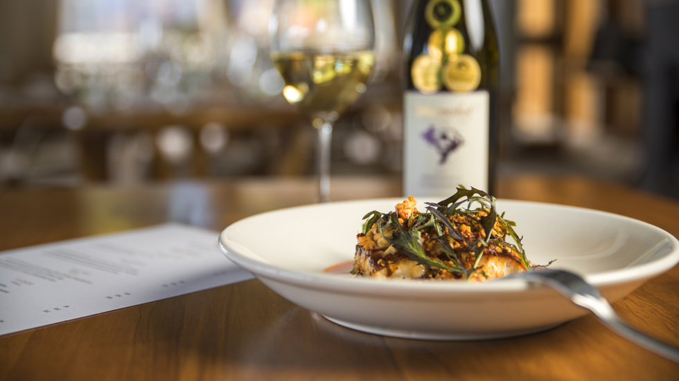 The Punga Fern Restaurant menu can include meals like this fresh Groper dish matched with a glass of local Marlborough wine at Punga Cove in the Marlborough Sounds of New Zealand's South Island