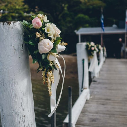 Beautiful floral bouquets are tied to the Punga Cove jetty to welcome guests for a wedding in Endeavour Inlet in the Marlborough Sounds, New Zealand