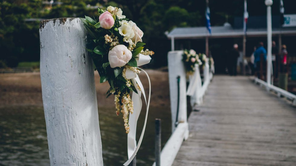 Beautiful floral bouquets are tied to the Punga Cove jetty to welcome guests for a wedding in Endeavour Inlet in the Marlborough Sounds, New Zealand