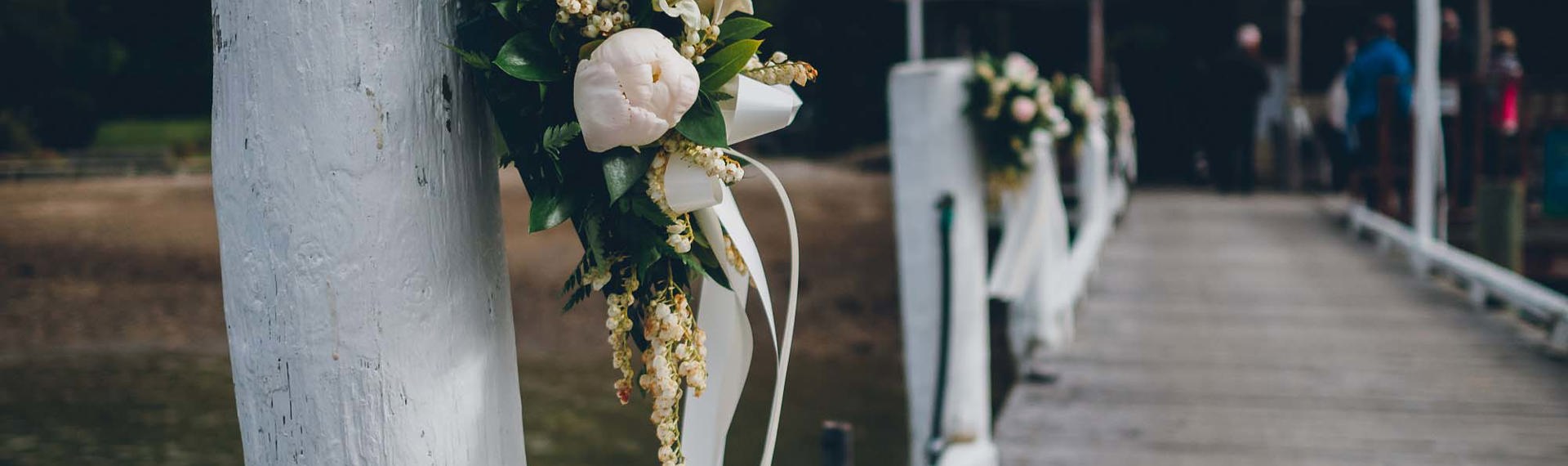 Beautiful floral bouquets are tied to the Punga Cove jetty to welcome guests for a wedding in Endeavour Inlet in the Marlborough Sounds, New Zealand