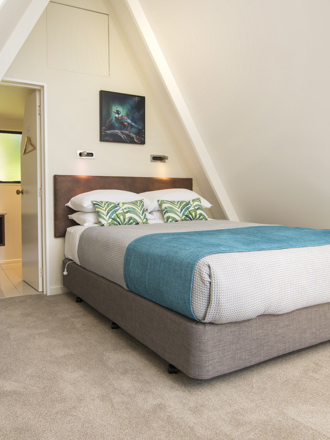 Koru Chalet accommodation rooms include a comfortable bedroom area with a Queen bed and side kitchenette at Punga Cove in the Marlborough Sounds in New Zealand's top of the South Island