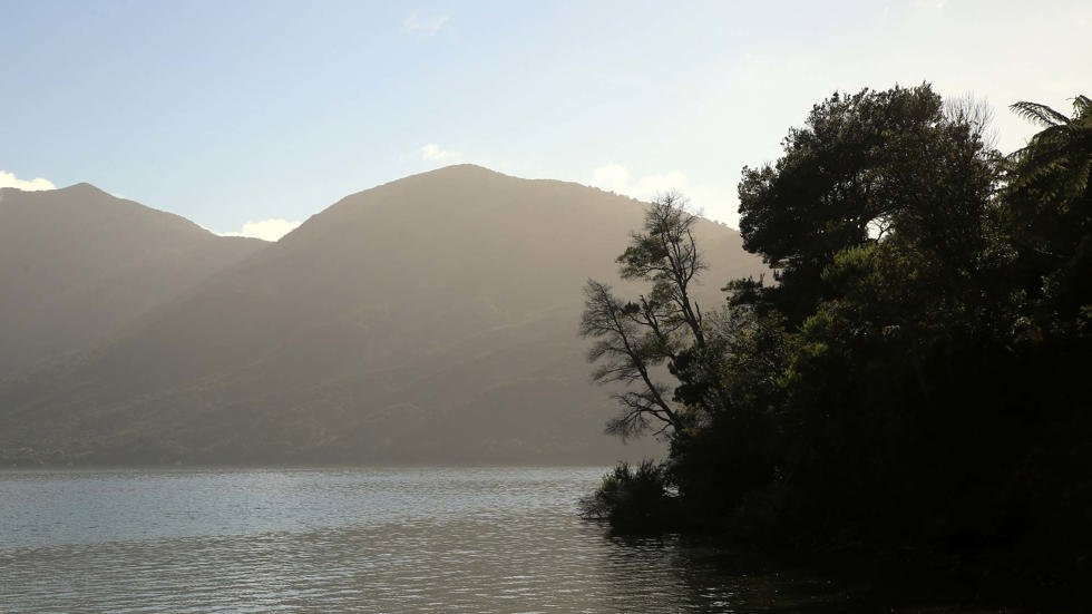 View the beautiful sunset from behind the hills at Punga Cove in the Marlborough Sounds of New Zealand's top of the South Island