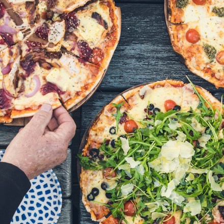 A family dining on the jetty at Punga Cove - a great way to enjoy stone baked pizza and more at the Boatshed Cafe and Bar.