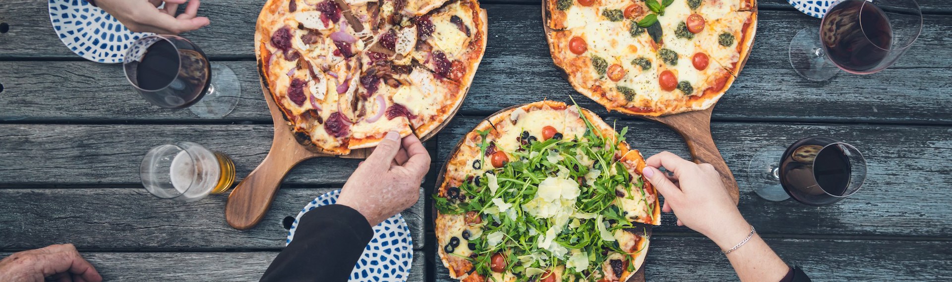 A family dining on the jetty at Punga Cove - a great way to enjoy stone baked pizza and more at the Boatshed Cafe and Bar.